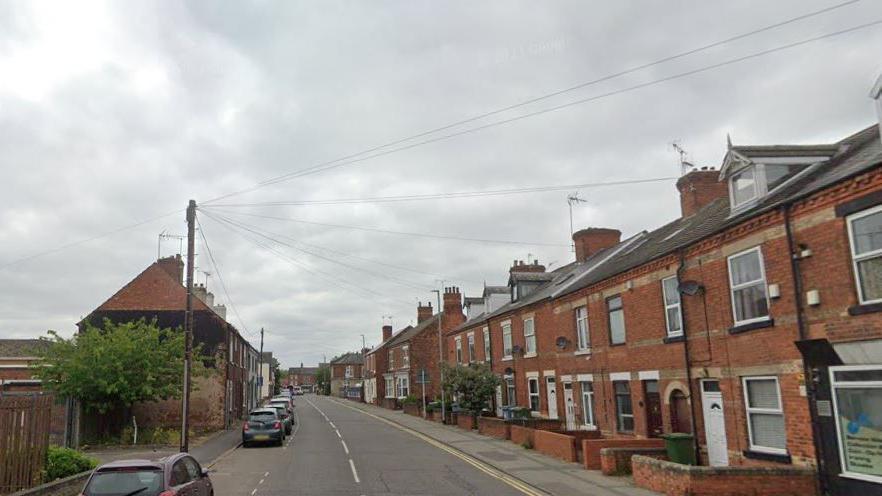 A Google street view of Eastgate, in Worksop. The photo is taken from the centre of the road and there are rows of terrace houses either side, with a line of cars parked on the left 