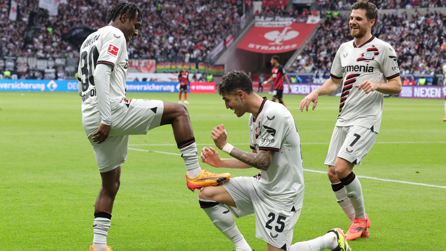 Jeremie Frimpong (left) celebrates scoring for Leverkusen against Eintracht Frankfurt by placing his boot on team-mate Exequiel Palacios' knee