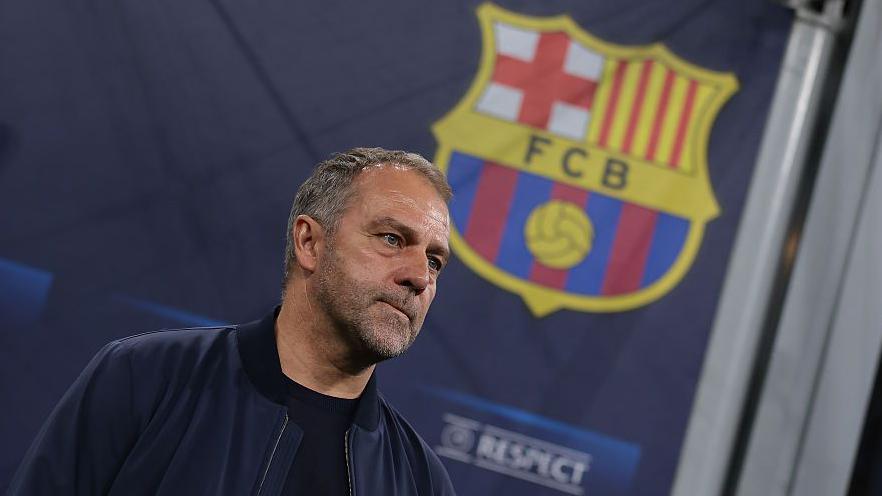 Hansi Flick with the Barcelona badge in the background.