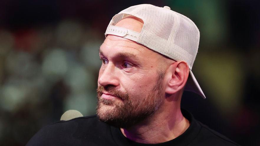 Tyson Fury, wearing a backwards baseball cap, staring into the distance