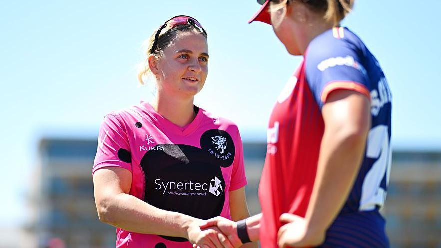 Niamh Holland (left) shakes hands with Grace Scrivens of Essex before the match got under way