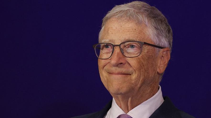 Bill Gates wearing a suit and glasses is pictured at an event at a hotel in New Delhi