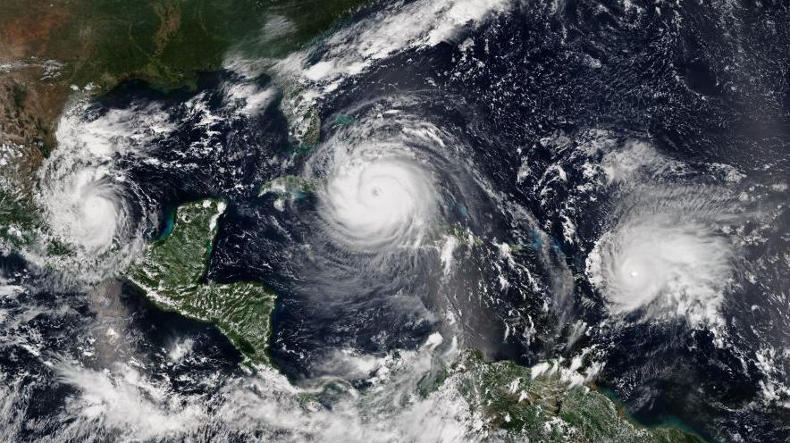A satellite image of three hurricanes hitting the Caribbean at the same time in September 2017. From left to right - Katia, Irma, and Jose