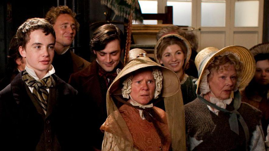 Scene from Cranford featuring a group image of (front row) Alex Etel, Imelda Staunton, Judi Dench, with back row of Tom Hiddleston, Matthew McNulty and Jodie Whittaker