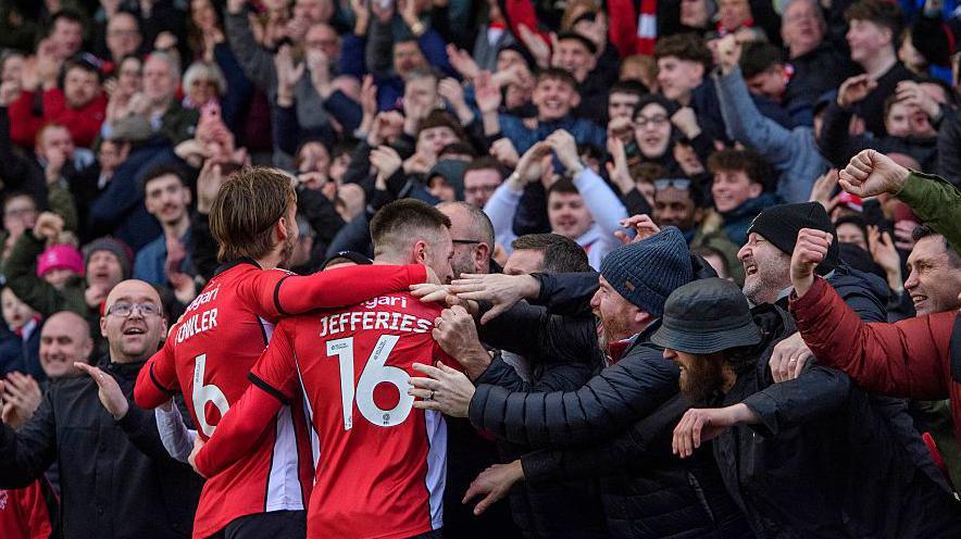 Lincoln players celebrate with fans during 4-0 win over Blackpool