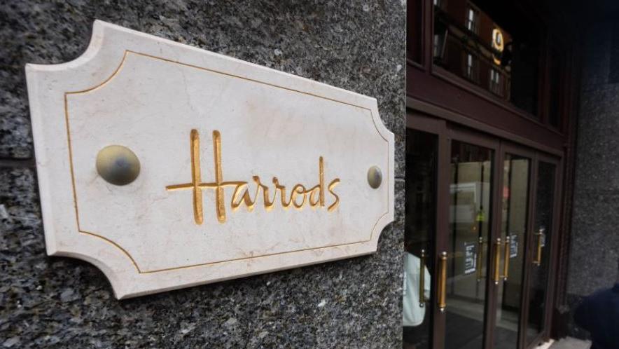 A file image showing a white and gold marble sign for Harrods next to an entrance to the store