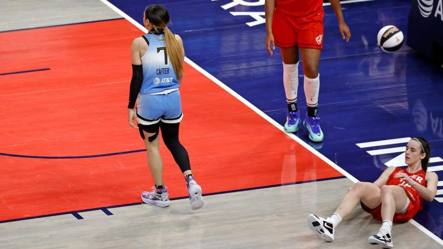 Caitlin Clark lies on the ground last Saturday after she was shoulder checked by Chennedy Carter, a player for the Chicago Sky. 