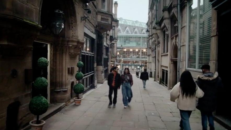 City Vaults pub seen in Virdee with some people walking up and down the narrow street beside it