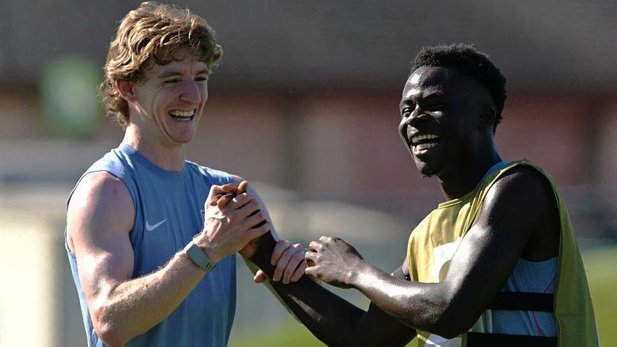 Anthony Gordon and Bukayo Saka smile during training for England at the World Cup