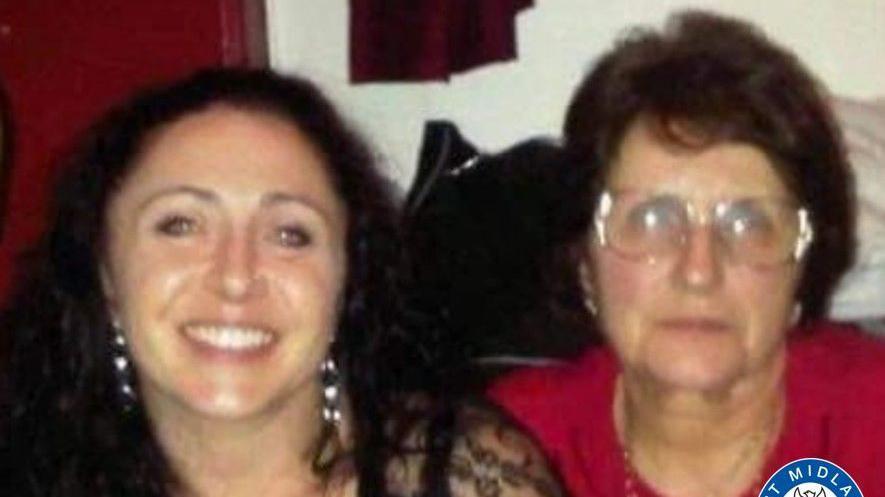 Amanda Riley is pictured smiling, she has curly long black hair. she is sat next to Linda Philips who wears large round glasses and has short brown hair. She is wearing a red shirt.