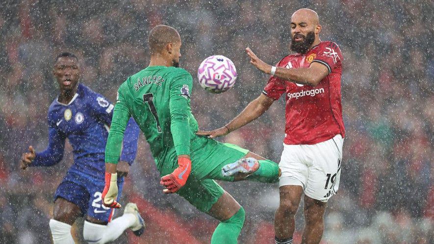 El portero del Chelsea, Robert Sánchez, derriba a Bryan Mbeumo del Manchester United en la primera mitad en Old Trafford