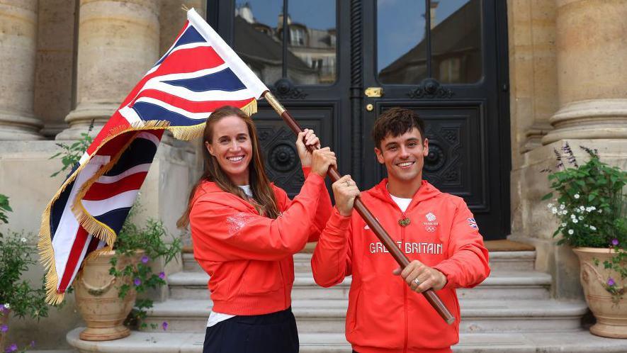 Helen Glover and Tom Daley of Great Britain pose for a photo with their national flag during the Team Great Britain Flagbearer photocall at British Embassy on July 24, 2024 in Paris, France. 