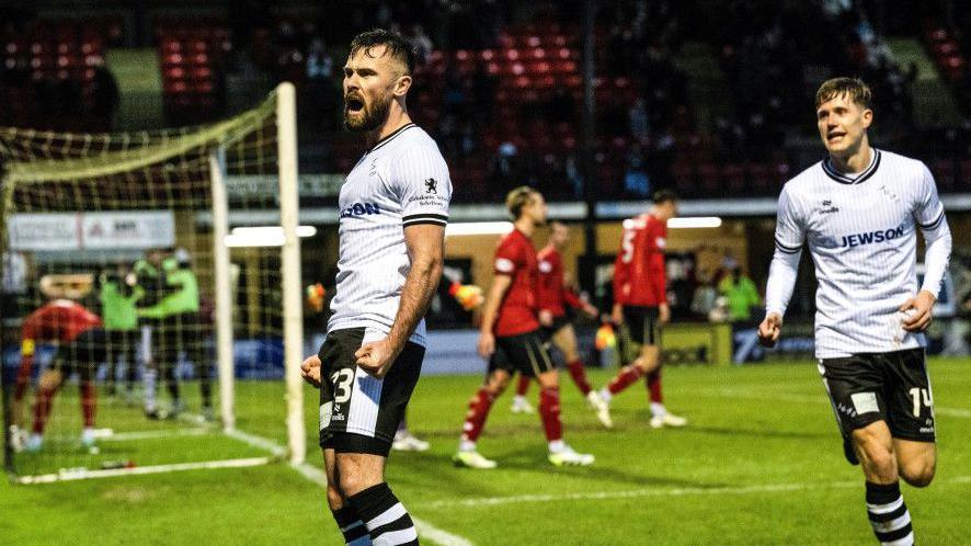 Scott McMann celebrates scoring to make it 3-2 to Ayr United