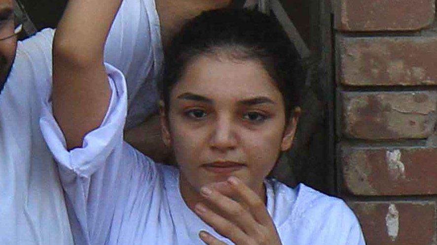 Sanaa Seif raises her hand after being released from prison for the funeral of her father (28 August 2014)