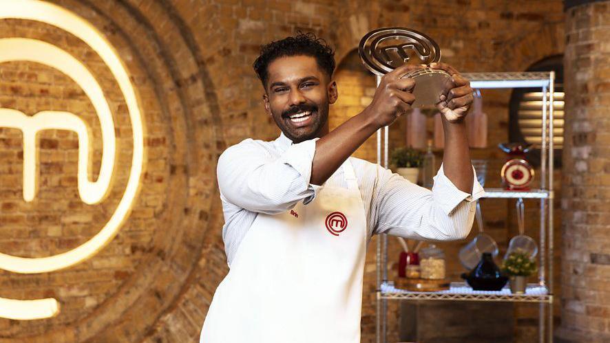 Brin Pirathapan holding the Masterchef winner's trophy