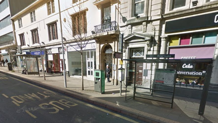 Street scene in Nottingham city centre with an entrance to an alleyway in the centre of the picture