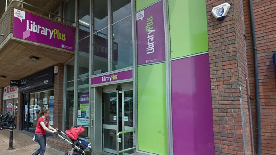 A street view shot of the library with a mother and baby going in