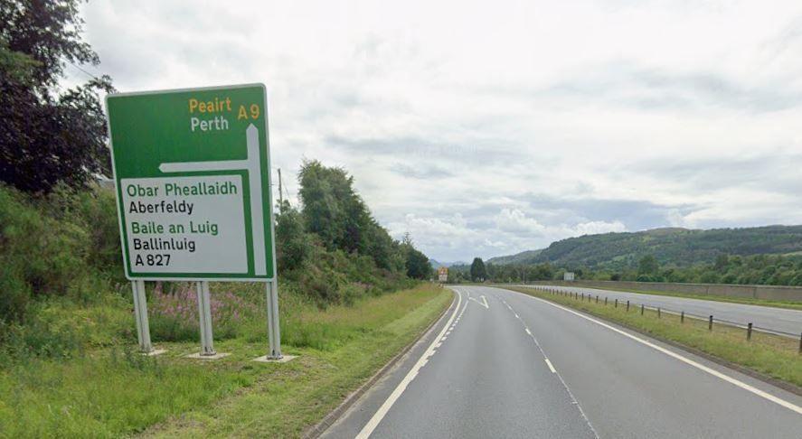 An empty dual carriageway with a road sign for Aberfeldy, Ballinluig, and Perth