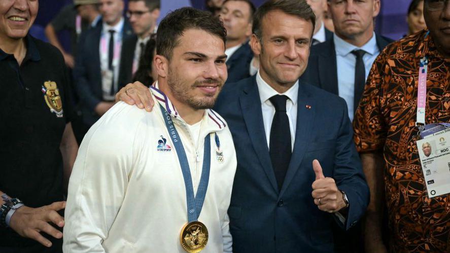 France's President Emmanuel Macron poses with France's Antoine Dupont