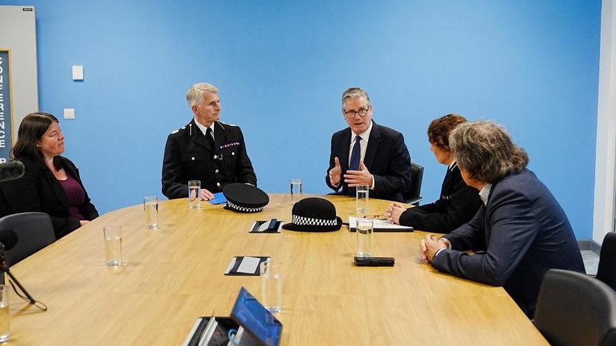 PCC Emily Spurrell; Dep Ch Con Chris Green, Sir Keir Starmer, ACC Jenny Sims and metro mayor Steve Rotheram sit around a large wooden conference table listening to the prime minister speak