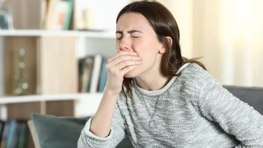 Woman feeling sick and holding her mouth and stomach