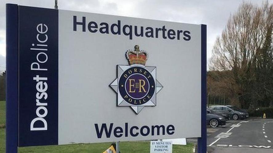 Blue and white sign saying: Dorset Police headquarters, welcome