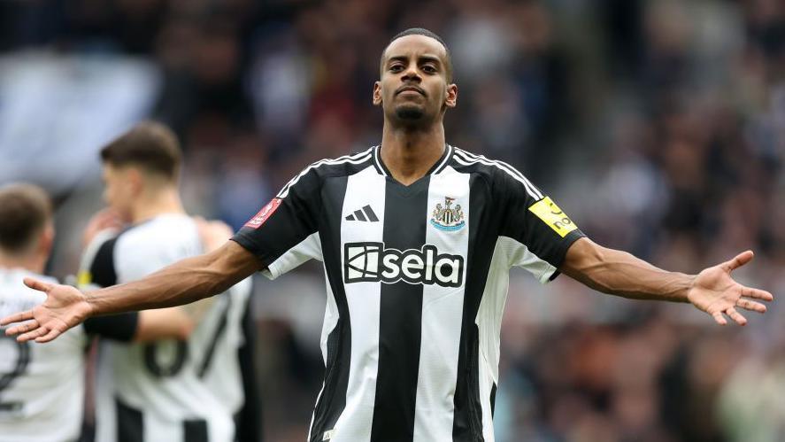 Alexander Isak celebrates a goal for Newcastle by holding his arms out wide.