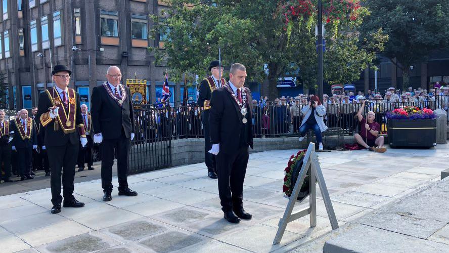 Loyal order members stand by as the governor of the Apprentice Boys, Graeme Stenhouse, lays a wreath