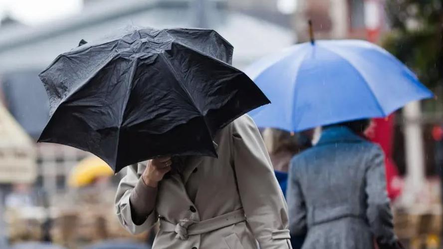 People with umbrellas in heavy rain 