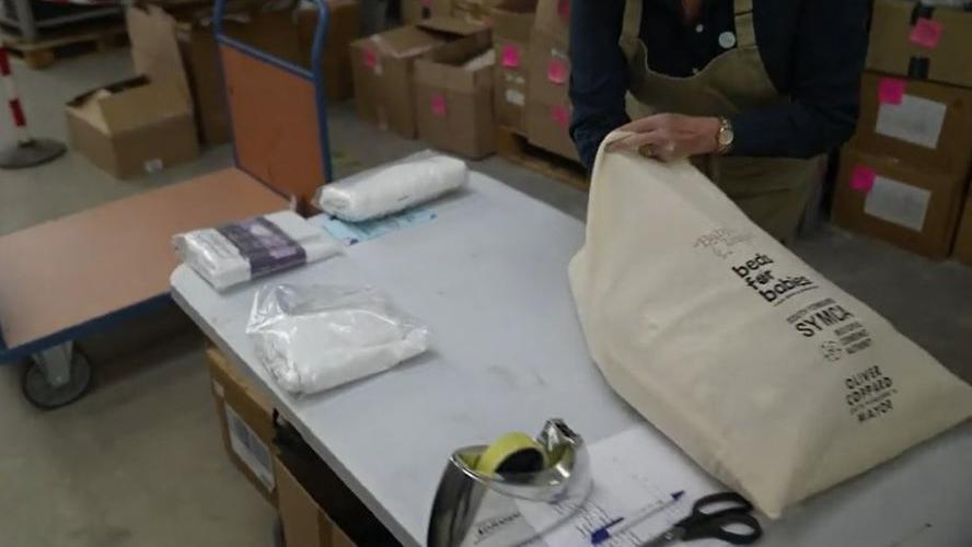 A worker at Baby Basics UK packs bedding that will be given to families in need