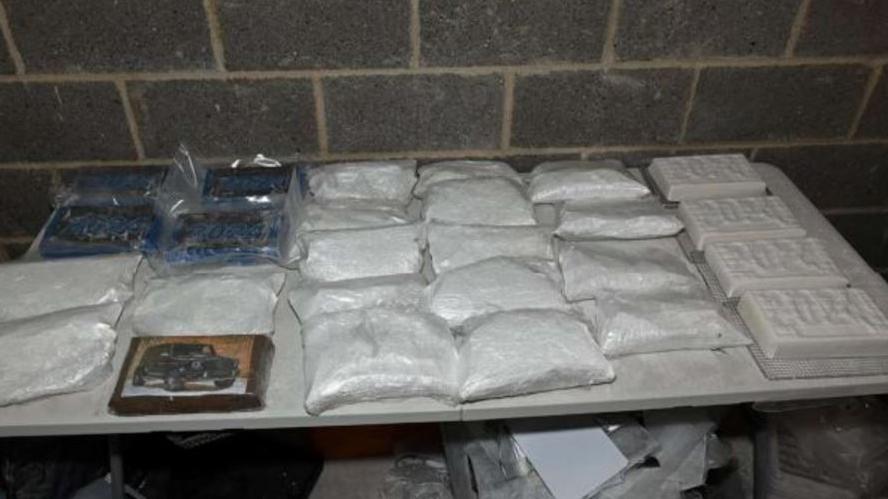 A table with bags of suspected cocaine laid out in rows