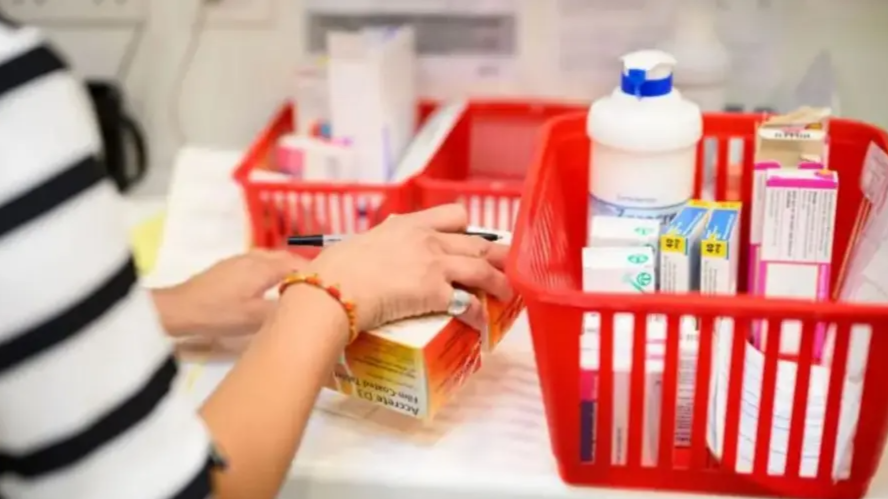 Image shows a pharmacy counter with baskets of prescriptions and medications 