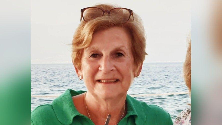 The picture shows Judith Brown wearing a green shirt, in the background is the sea.