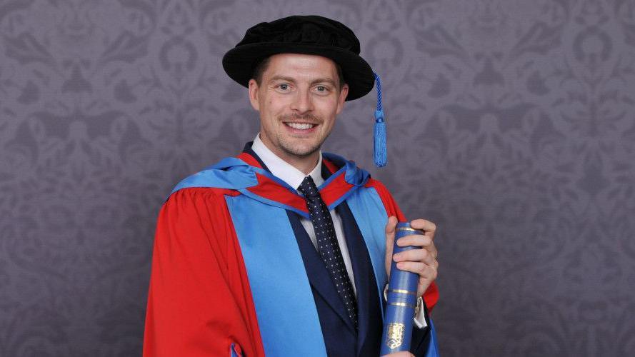 Dr Alex George in graduation gown