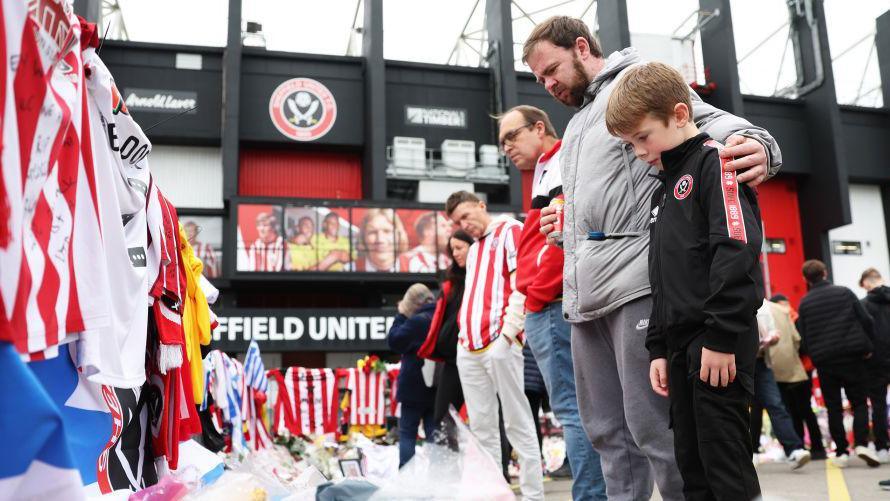 Sheffield United fans look at tributes set out for George Baldock