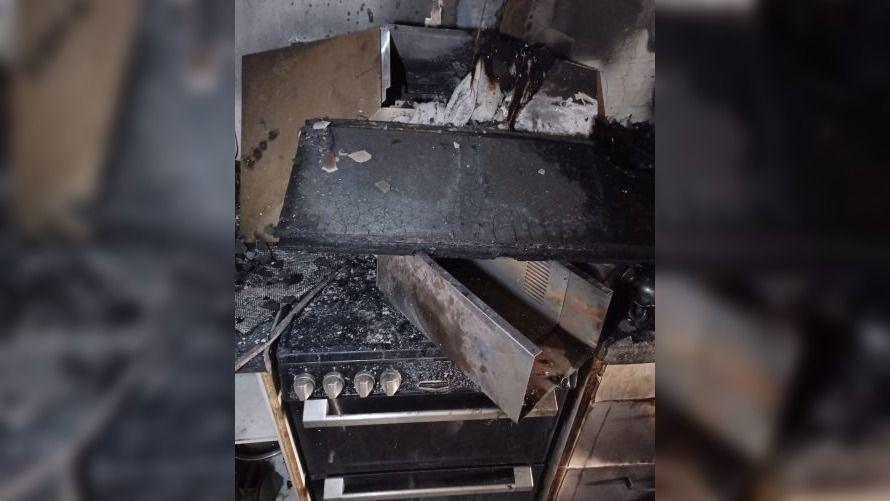 A cooker hood which has collapsed on to the hob below. It is burnt and covered in black soot.