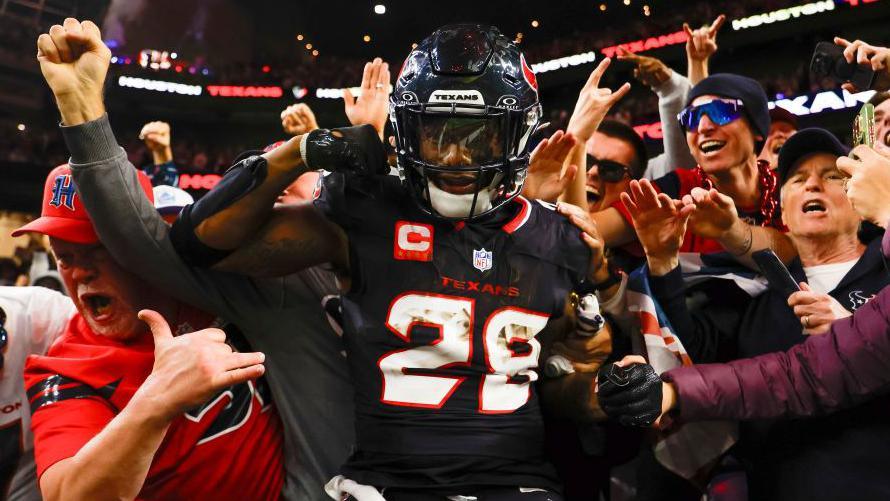 Joe Mixon celebrates scoring a touchdown against the Los Angeles Chargers, surrounded by Houston Texans fans