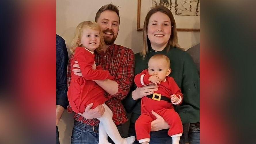 Lewis Daines with his wife and two children all wearing festive clothes