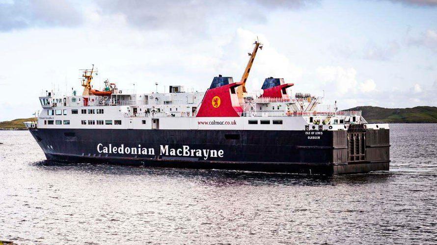 A large ferry is sailing under a sky with scattered clouds. The ferry is predominantly black and white with some red accents on its funnels.