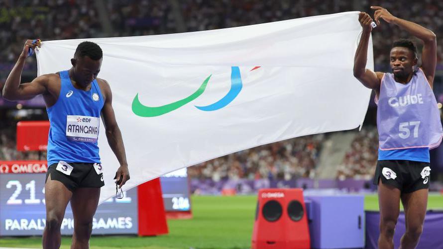 Visually impaired athlete Guillaume Junior Atangana, known as Junior, and his guide Donard Nyamjua with the RPT flag