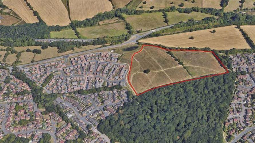 A satellite image showing existing housing, Chaddesden Wood, and the proposed site of new housing bordered by a red line.