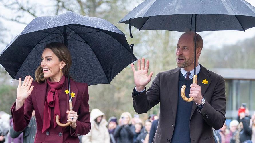 Catherine, Princesha e Uellsit, dhe William, Princi i Uellsit, duke mbajtur çadra ndërsa përshëndetin turmat në një aktivitet në Uells