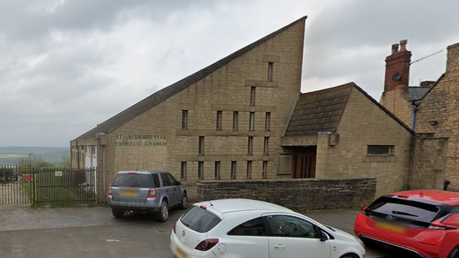 Sloped roof on a church building with hills in the background