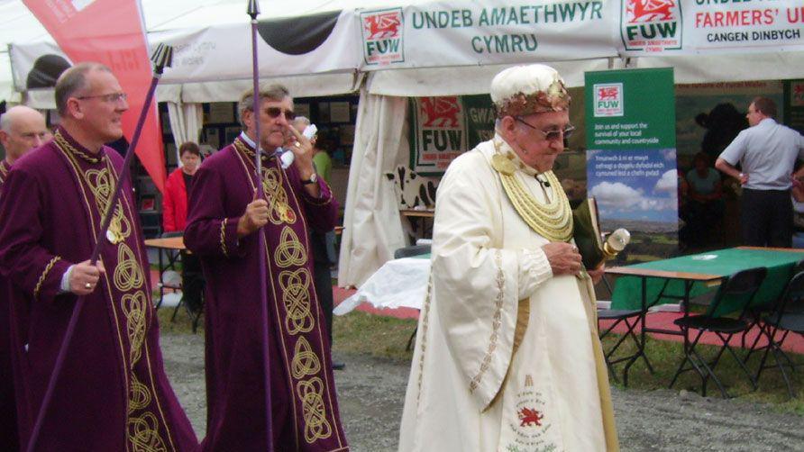 Aled Roberts yn cerdded gyda'r Orsedd