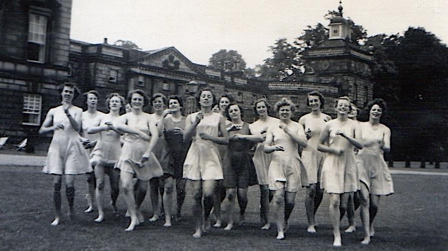A historic photo of Lady Mabel College, depicting a group of women jogging across the grounds of the Georgian-era stately home, Wentworth Woodhouse. 