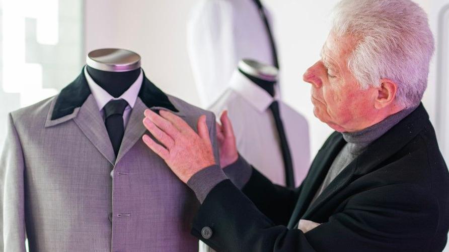 George Millings, the son of the designer of the Beatles' Hard Day's Night suits, looks at one of the suits that he has recreated based on the original designs. 