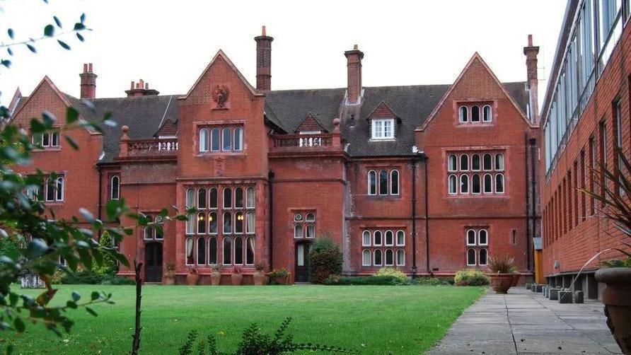 An image of the Mount Browne site. A brick building can be seen with an area of grass in front of it. 