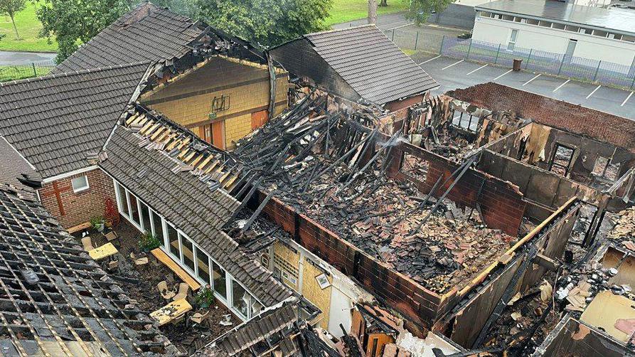 An aerial image of the fire damage caused to the Church of the Holy Name and its adjacent hall last weekend.   The image shows that large section of the roof had collapsed and charred embers fill the remaining structure.