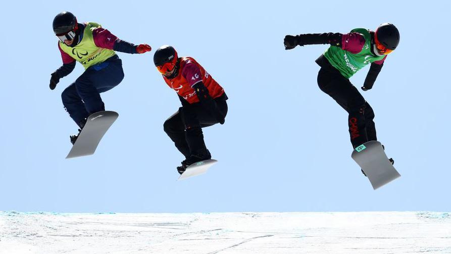 Britain's James Barnes-Miller and China's Zhu Younggang and Ji Lijia in action in the snowboard cross semi-finals at the Beijing Paralympics