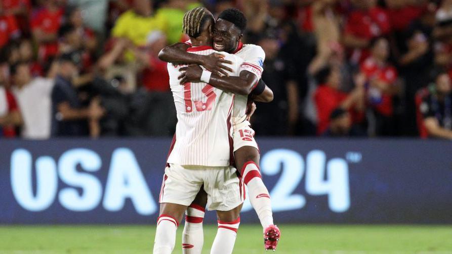 Two Canada players hug in celebration